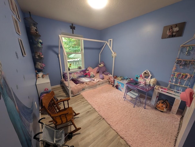 bedroom featuring wood-type flooring and a textured ceiling