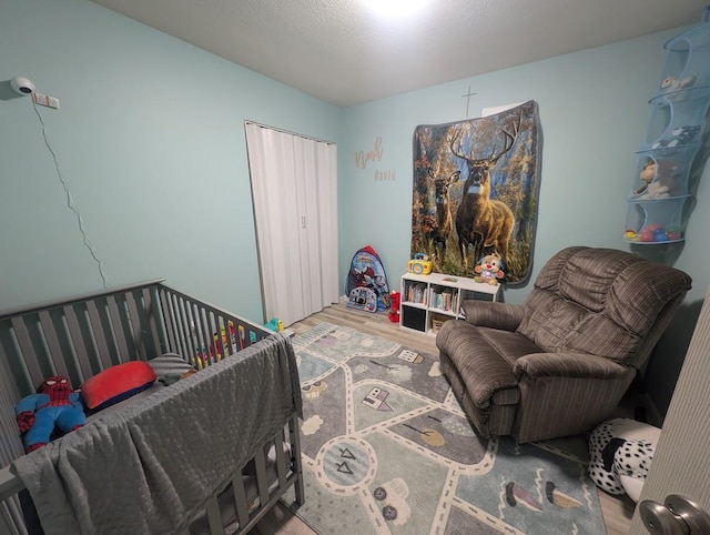 bedroom with hardwood / wood-style flooring and a crib