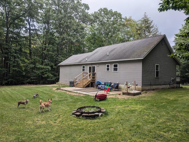 rear view of house with an outdoor fire pit, a patio, and a yard