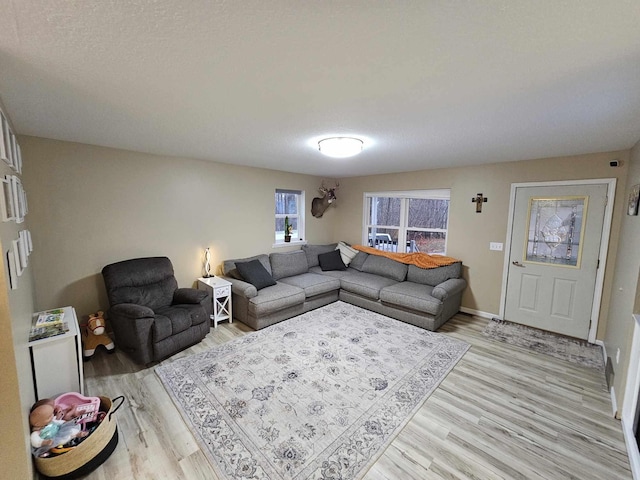 living room featuring light hardwood / wood-style flooring and a textured ceiling