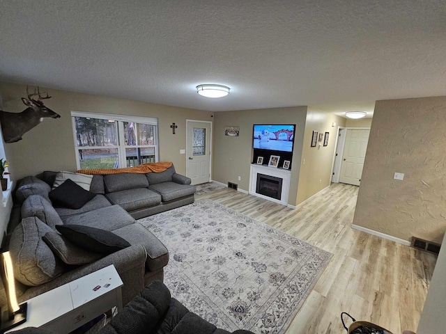 living room featuring a textured ceiling and light hardwood / wood-style flooring