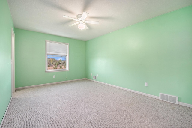 empty room featuring carpet, visible vents, ceiling fan, and baseboards