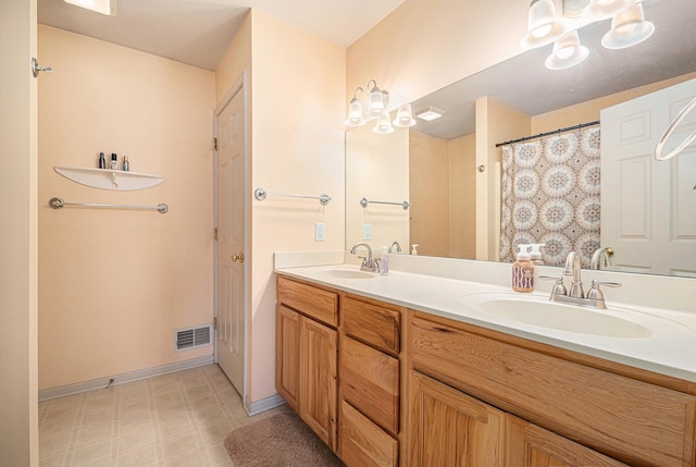 bathroom featuring tile patterned floors, visible vents, a sink, and double vanity