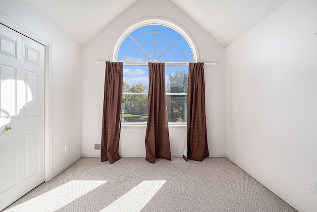 carpeted foyer with lofted ceiling and baseboards