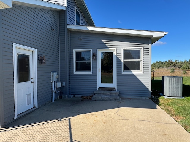 rear view of house featuring entry steps, central AC, a patio, and fence