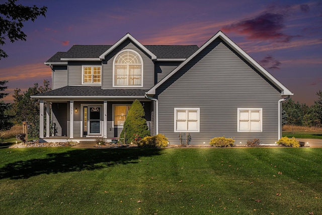 view of front of home featuring covered porch, a front lawn, and a shingled roof