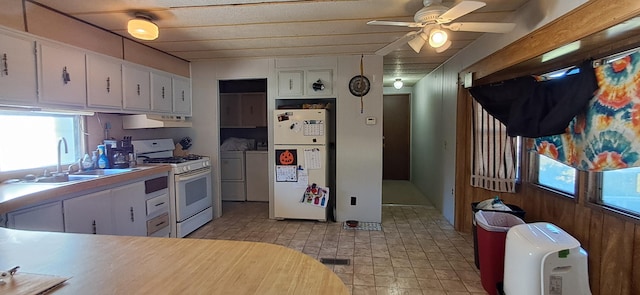 kitchen featuring extractor fan, white cabinets, white appliances, sink, and washing machine and clothes dryer