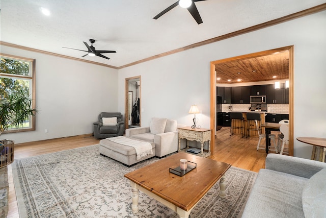 living room featuring ceiling fan, light wood-type flooring, ornamental molding, and wood ceiling