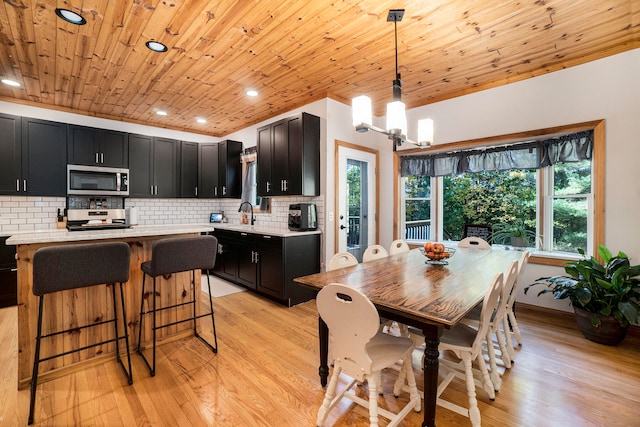 dining room featuring plenty of natural light, wood ceiling, light hardwood / wood-style flooring, and sink