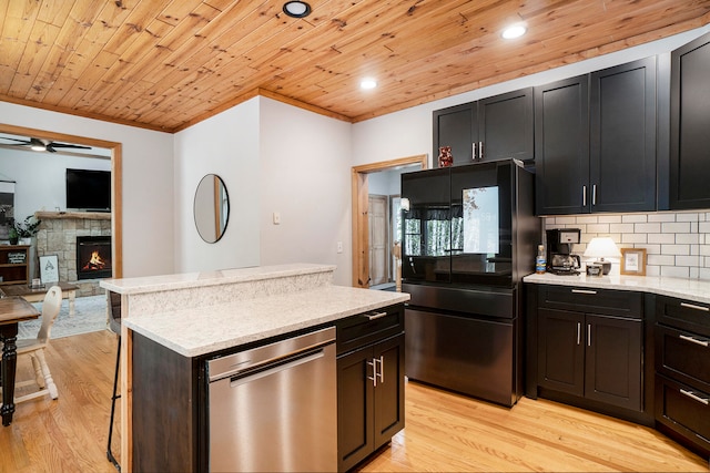 kitchen featuring light stone counters, wood ceiling, light hardwood / wood-style flooring, a fireplace, and black refrigerator