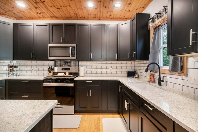 kitchen featuring light hardwood / wood-style floors, sink, stainless steel appliances, and light stone countertops