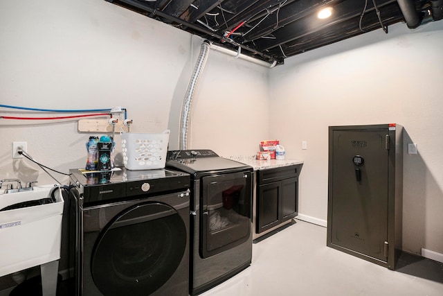 clothes washing area with washer and dryer and sink