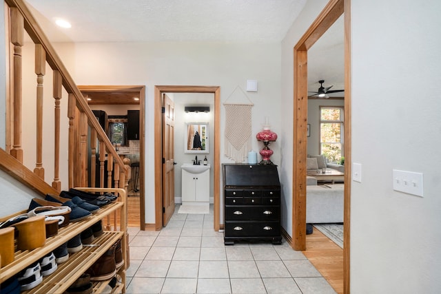 corridor featuring sink and light tile patterned floors