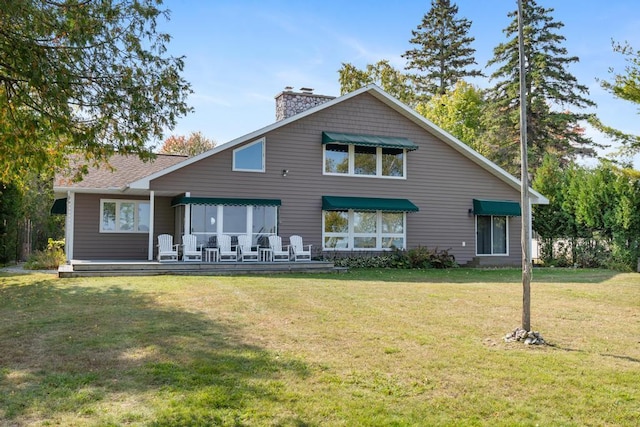 rear view of property with a lawn and a deck