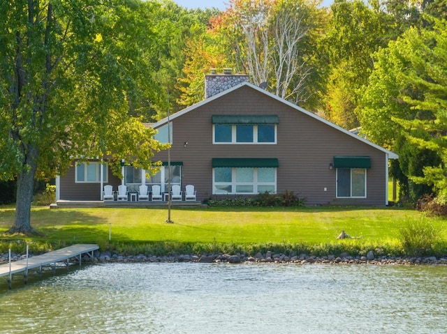 rear view of property with a water view and a yard