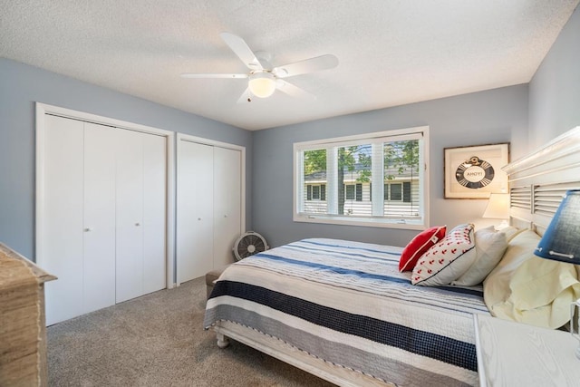 bedroom with ceiling fan, carpet floors, a textured ceiling, and multiple closets