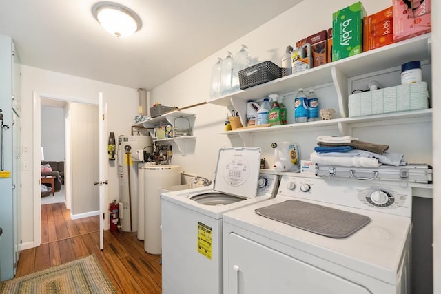 laundry room with water heater, washer and dryer, gas water heater, and hardwood / wood-style flooring