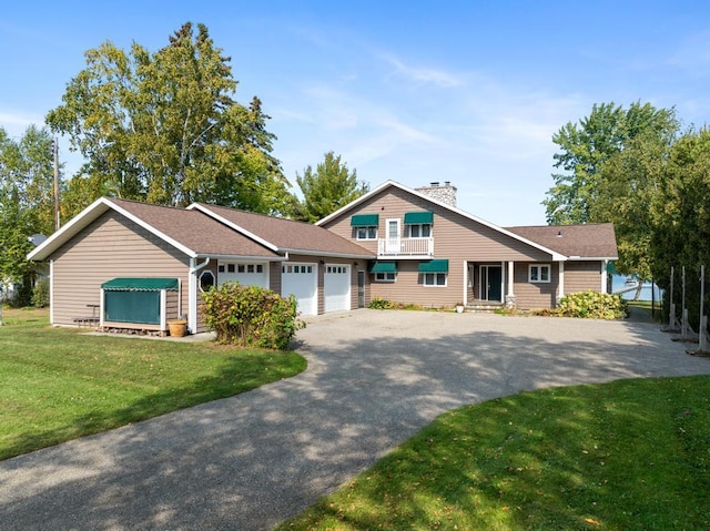 view of front of house with a front yard, a balcony, and a garage