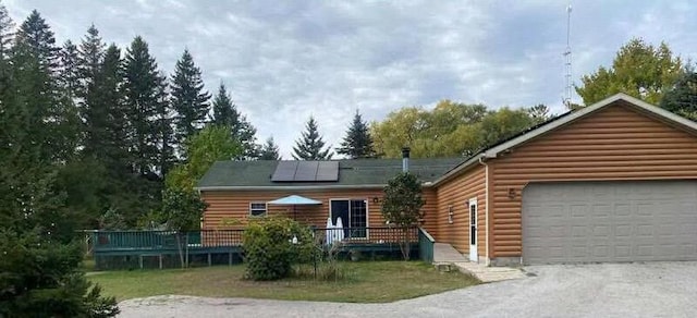 log-style house with a garage and solar panels