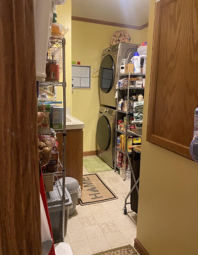 laundry room featuring stacked washing maching and dryer and ornamental molding