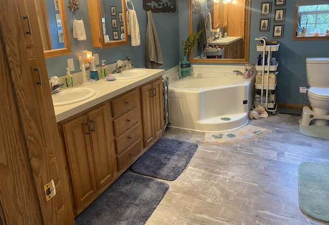 bathroom with a bathing tub, vanity, and toilet