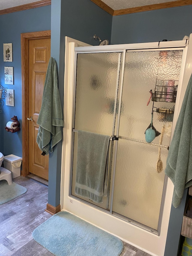 bathroom with an enclosed shower, a textured ceiling, and ornamental molding