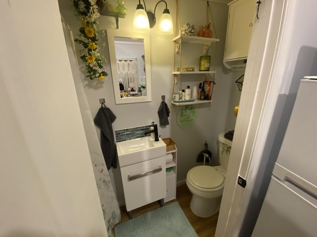 bathroom with hardwood / wood-style floors, vanity, and toilet