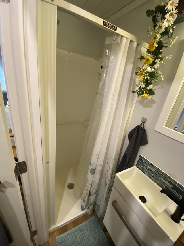 bathroom with hardwood / wood-style flooring, vanity, and curtained shower