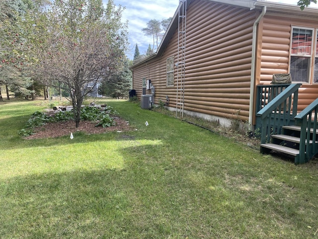 view of side of home with central AC unit and a lawn