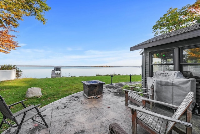 view of patio with area for grilling, a water view, and an outdoor fire pit