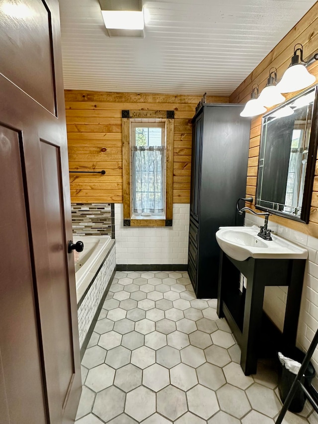 bathroom featuring sink, wooden walls, and a bath