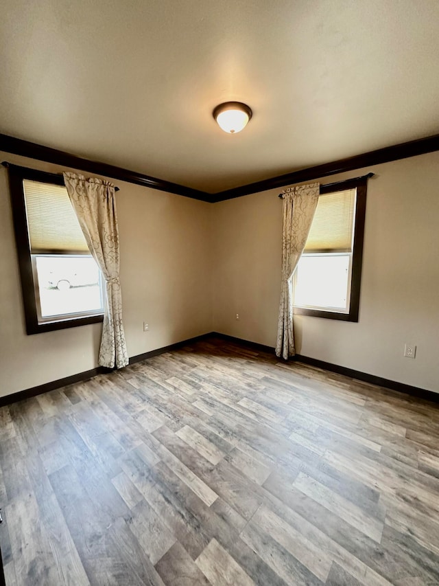 unfurnished room with hardwood / wood-style flooring and ornamental molding