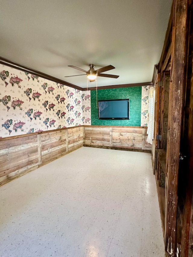 empty room featuring ceiling fan and crown molding