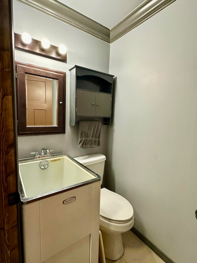 bathroom featuring vanity, ornamental molding, toilet, and tile patterned flooring