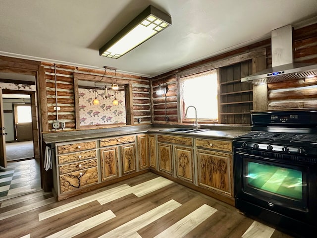 kitchen featuring black range with gas stovetop, light hardwood / wood-style flooring, wall chimney exhaust hood, and sink