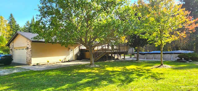 view of yard featuring a garage and a swimming pool side deck