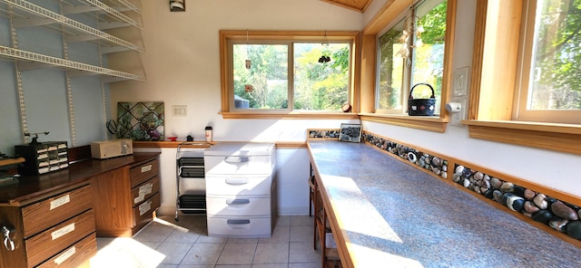 kitchen with light tile patterned flooring and vaulted ceiling