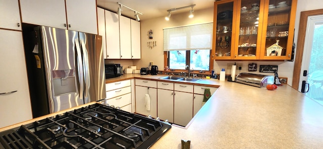 kitchen with stainless steel fridge, black gas cooktop, sink, and white cabinets