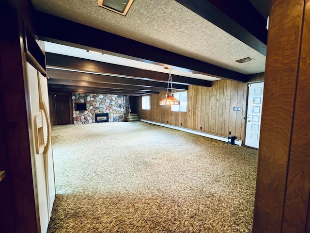 basement featuring a baseboard radiator, wooden walls, a fireplace, and carpet