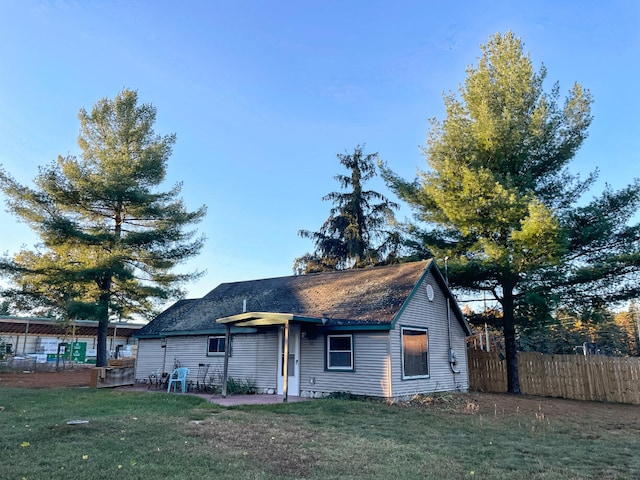 rear view of house featuring a yard