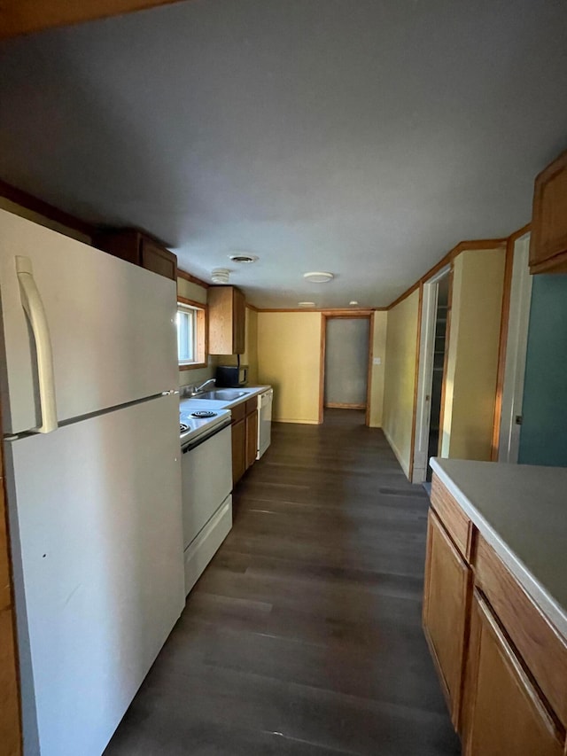 kitchen with dark hardwood / wood-style flooring, sink, and white appliances