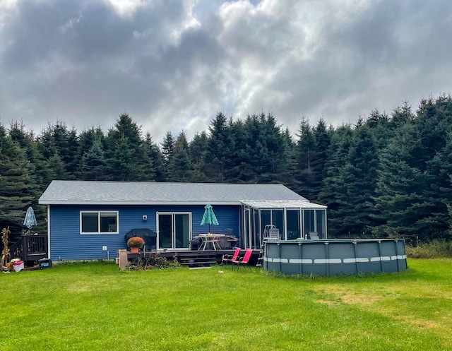 rear view of property with a sunroom and a yard