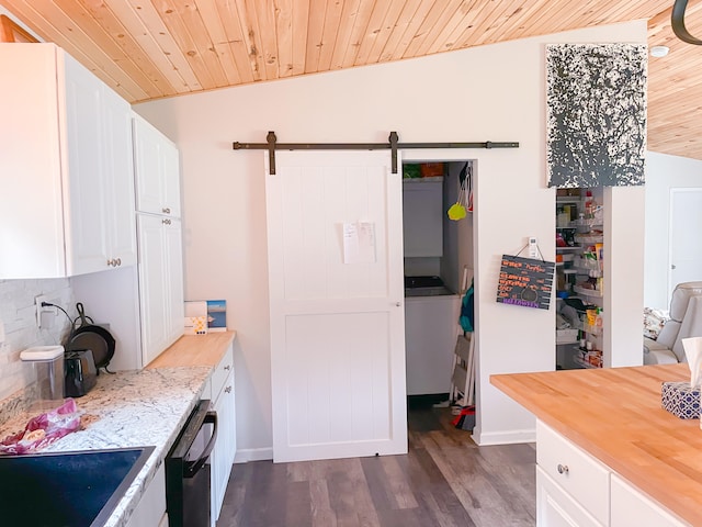 kitchen featuring a barn door, dishwasher, wooden ceiling, and white cabinets