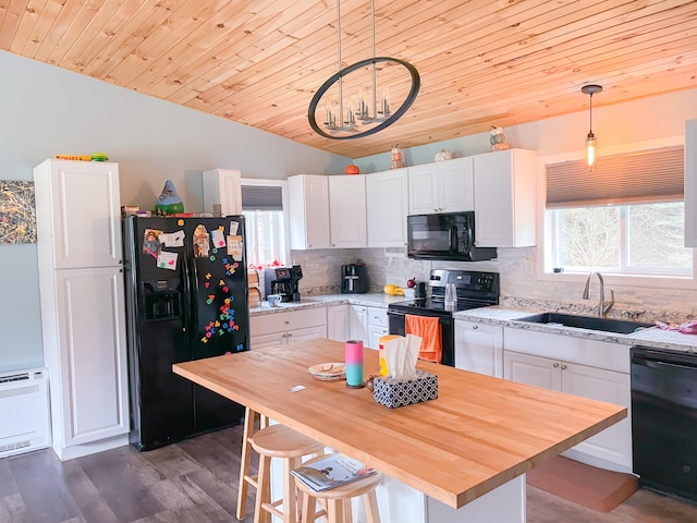 kitchen featuring pendant lighting, white cabinets, and black appliances