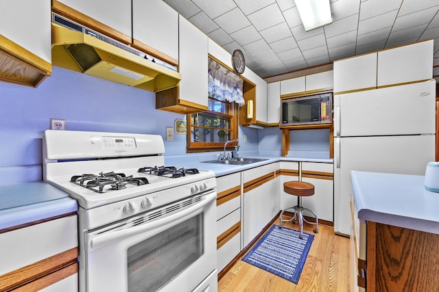 kitchen with sink, white cabinets, light hardwood / wood-style flooring, and white appliances