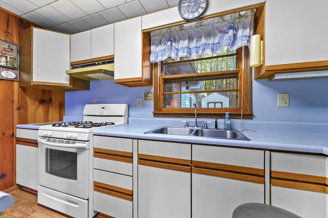 kitchen featuring sink, white range with gas cooktop, and white cabinetry