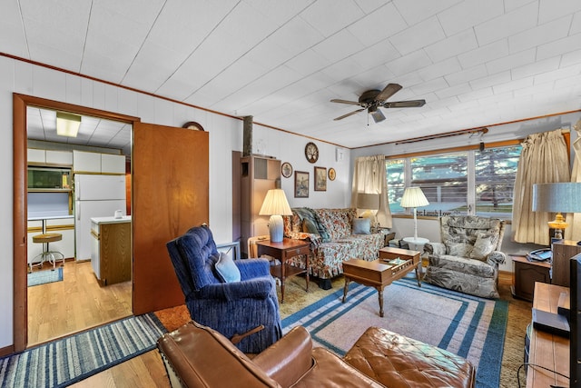 living room featuring crown molding, light wood-type flooring, and ceiling fan