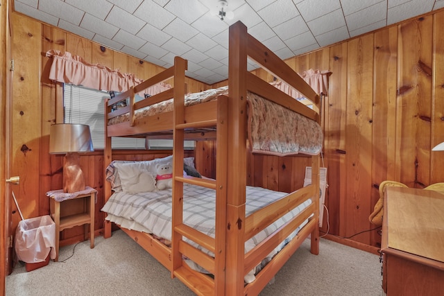 carpeted bedroom with wood walls