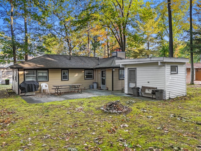 back of house featuring a patio area and a lawn