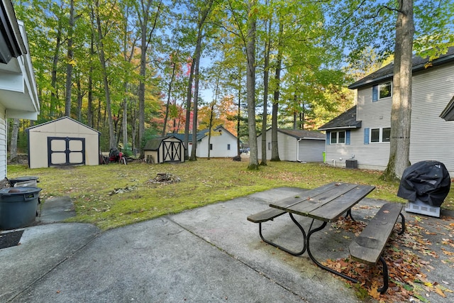 view of yard with cooling unit, a shed, and a patio